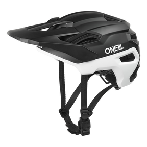 El casco O'NEAL Trailfinder EVO Solid en blanco y negro incorpora visera, orificios de ventilación y correas ajustables para la barbilla, mostrado de perfil sobre fondo blanco.