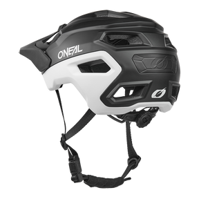 El Casco O'NEAL Trailfinder EVO Solid en blanco y negro tiene múltiples aberturas de ventilación, correas ajustables, una rueda de ajuste trasera y es compatible con el Sensor Quin Smart Safety. Mostrado desde atrás sobre fondo blanco.