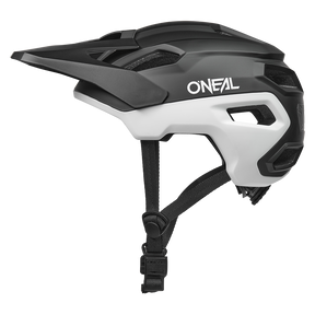 El casco O'NEAL Trailfinder EVO Solid en blanco y negro tiene visera y mentonera ajustable. En la foto aparece desde el lado izquierdo sobre un fondo blanco liso.