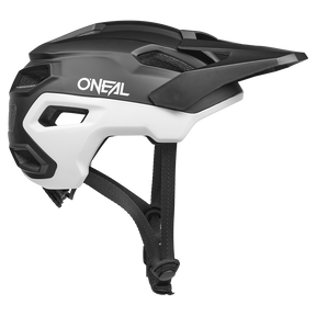 El casco O'NEAL Trailfinder EVO Solid de O'NEAL se muestra en blanco y negro con visera, aberturas de ventilación y mentonera ajustable en vista lateral sobre fondo blanco.