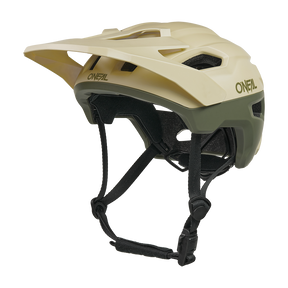El casco O'NEAL Trailfinder EVO Solid es un casco de bicicleta de montaña de color beige y verde oliva con visera, múltiples aberturas de ventilación, correa negra ajustable para la barbilla y compatible con el Sensor de Seguridad Inteligente Quin opcional.