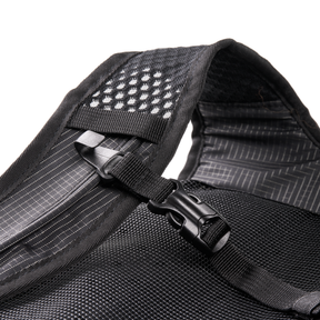 Nahaufnahme eines schwarzen Mesh-Gurtes mit Kunststoffschnalle und reflektierenden Punkten auf der gepolsterten Schulterpartie, die die Eigenschaften des O'NEAL JUNCTION MTB Protektorrucksacks von O'NEAL Europe hervorheben, vor einem weißen Hintergrund.