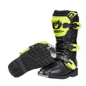 Ein Paar schwarze O'NEAL RIDER PRO Stiefel Kinder Motocross-Stiefel mit leuchtend gelben Schnallen und Akzenten, robusten Sohlen und verstärkten Zehenkappen. Ein Stiefel steht aufrecht; der andere liegt auf der Seite, um das Sohlenprofil zu zeigen.