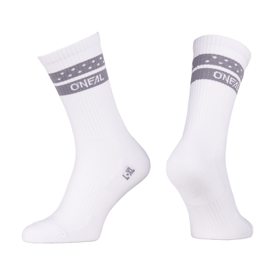 Deux chaussettes blanches O'NEAL VTT Performance SOLID avec des rayures grises et des petits points blancs sur le bord supérieur. "O'NEAL" est imprimé en blanc sur la bande. Affichée sur des formes de pied invisibles sur un fond blanc.