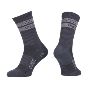Une paire de chaussettes O'NEAL VTT Performance SOLID en gris avec des bandes gris clair et l'inscription "O'NEAL" sur le poignet et le pied, montrées du côté et sous un angle pour montrer à la fois l'avant et l'arrière.