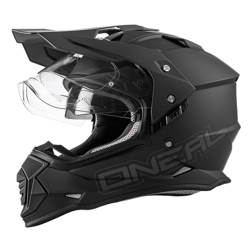 Le casque O'NEAL SIERRA FLAT en noir mat dispose d'une visière claire, d'ouvertures d'aération anguleuses et d'un protège-menton prononcé qui met en valeur la technique O'NEAL dans le design des casques moto et vélo, ici à gauche sur fond transparent.