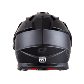 Vue arrière du casque SIERRA de O'NEAL en noir mat avec un design géométrique, des détails d'aération et un autocollant DOT sur la base.