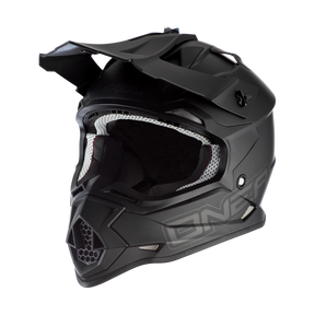 Der O'NEAL 2SRS Helm FLAT ist ein mattschwarzer Fullface-Motocross-Helm mit einem markanten Visier, einem großen Kinnschutz und einer Innenausstattung aus weißem Mesh - ideal für ernsthafte Fahrer. Fotografiert auf einem weißen Hintergrund.