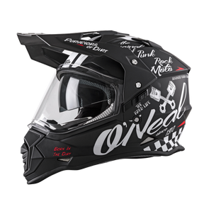 The O'NEAL SIERRA helmet TORMENT is a black bike helmet from O'NEAL with a clear visor, white "Rock Moto" and "Born in the Dirt" graphics as well as a wrench and checkered pattern.