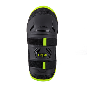 La genouillère O'NEAL PEEWEE pour enfants en noir et jaune fluo, avec rembourrage de protection et fermeture velcro, est représentée de haut en bas sur un fond noir.