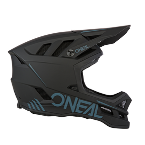 Der O'NEAL BLADE Polyacrylite Helm SOLID ist ein mattschwarzer Integralhelm mit blauen Akzenten und Lüftungsschlitzen, ideal für Motocross oder Mountainbiking.