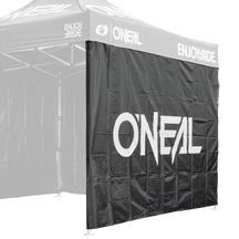 Eine schwarze O'NEAL RACE TENT Seitenwand mit "O'NEAL" und "ENJOY THE RIDE." in Weiß auf dem Vordach und der Seitenwand. Der metallene Zeltrahmen ist teilweise sichtbar.