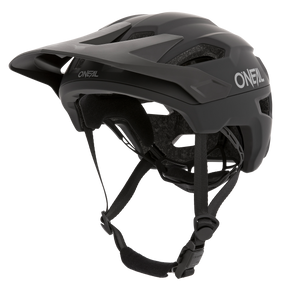 Le casque O'NEAL TRAILFINDER SOLID en noir dispose d'une visière ajustable, de jugulaires et d'un design aérodynamique. Pour plus de confort et de protection, il dispose de trous d'aération et d'un rembourrage intérieur. Le logo O'Neal est clairement visible sur le côté et sur le devant du casque.