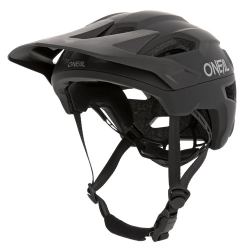 Le casque O'NEAL TRAILFINDER SOLID en noir dispose d'une visière ajustable, de jugulaires et d'un design aérodynamique. Pour plus de confort et de protection, il dispose de trous d'aération et d'un rembourrage intérieur. Le logo O'Neal est clairement visible sur le côté et sur le devant du casque.