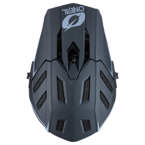 Draufsicht auf den O'NEAL BACKFLIP Helm SOLID in mattem Schwarz mit geometrischen Belüftungsöffnungen und weißem O'NEAL-Logo - ideal für Ihr nächstes Mountainbike-Abenteuer.