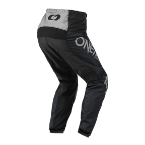 Pantalón O'NEAL Matrix RIDEWEAR en negro y gris, con logotipo O'NEAL y gráficos blancos en la pernera izquierda, visto desde atrás: el equipamiento ideal de motocross para más seguridad en cada salida.