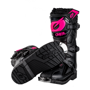 Ein Paar schwarze O'NEAL RIDER PRO Stiefel Kinder mit leuchtend pinken O'NEAL-Logos und -Akzenten - ein Stiefel stehend, einer liegend, um die robuste Sohle und die Schnallen zu zeigen. Die perfekten Offroad-Stiefel für junge Reiter.