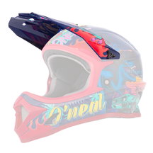 El Casco Juvenil O'NEAL Visor Sonus Rex es un colorido casco de motocross con llamativos gráficos que muestran un T-Rex azul, una furgoneta verde, palmeras, elementos de la puesta de sol y el nombre de la marca "O'NEAL" en el lateral.