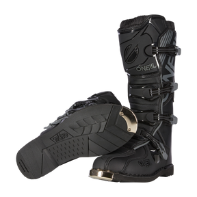 Ein Paar O'NEAL TRIBUTE Stiefel in Schwarz mit strukturierten Sohlen, Metallkappen und verstellbaren Schnallen wird aufrecht und auf der Seite gezeigt, um die Vorder- und Unterseite zu zeigen - die perfekte Motocross-Ausrüstung für Motorsport-Fans.
