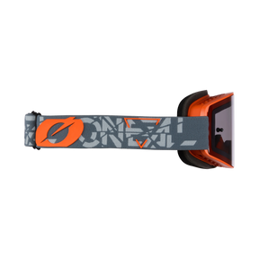 Seitenansicht der O'NEAL B-20 Brille STRAIN, einer orange-schwarzen Ski- oder Motocross-Brille mit grauem, verstellbarem Band, orangem Logo und grafischem Design, die ein breites Sichtfeld bietet, isoliert auf schwarzem Hintergrund.