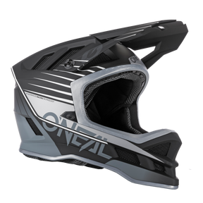 El casco O'NEAL Blade DELTA de poliacrilita es un casco integral de BTT negro y gris con la marca "O'NEAL" en blanco, una robusta visera y múltiples aberturas de ventilación, perfecto para los ciclistas de montaña profesionales.