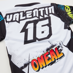 Le O'NEAL Custom Jersey enfants VILLAIN est fabriqué à la main en Allemagne, il porte le nom "VALENTIN" et le numéro "16" sur le dos et présente un logo coloré avec des graphiques dynamiques en noir, blanc, jaune et rouge.