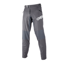 Los pantalones O'NEAL Legacy, diseñados para los aficionados a las dos ruedas e inspirados en Greg Minnaar, presentan bolsillos con cremallera y refuerzos en las rodillas, aquí en gris sobre fondo blanco.