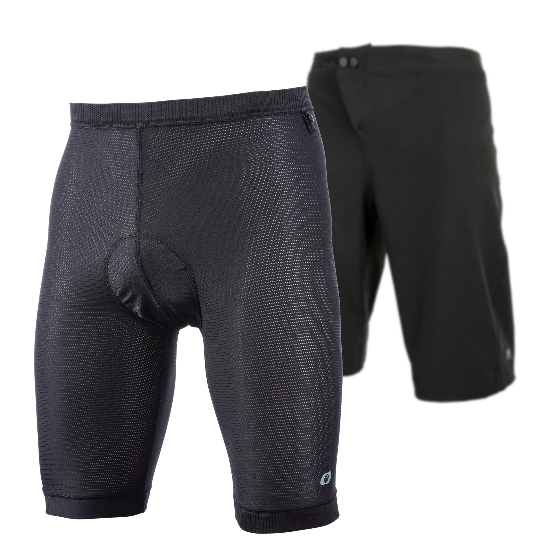 Im Vordergrund die O'NEAL MATRIX Chamois Shorts mit gepolstertem Innenfutter, dahinter die schlichte schwarze Außenhose - beides von O'NEAL -, die für den Radsport konzipiert wurde und ideal für die MTB-Ausrüstung ist.