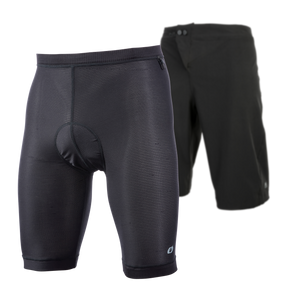 In primo piano i pantaloncini scamosciati O'NEAL Matrix con fodera interna imbottita, dietro i pantaloncini esterni neri a tinta unita - entrambi di O'NEAL - progettati per il ciclismo e ideali per l'attrezzatura da MTB.
