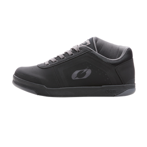 Las zapatillas de pedal O'NEAL Pinned PRO FLAT de O'NEAL son unas deportivas negras con detalles grises, cordones, corte bajo en el tobillo y suela texturizada. El estilo inspirado en las zapatillas de ciclismo y el sutil logotipo aparecen sobre un fondo negro liso.