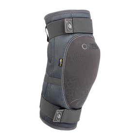 El protector de rodilla O'NEAL DIRT en gris cuenta con correas ajustables y acolchado para la protección deportiva, garantizando un apoyo fiable y comodidad durante las actividades intensas. Se muestra sobre fondo negro.
