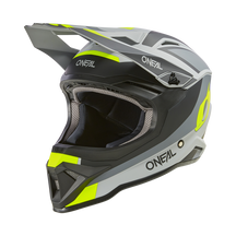 El casco O'NEAL 1SRS para niños STREAM es un casco de motocross ABS de alta calidad en negro, gris y amarillo neón con aberturas de ventilación aerodinámicas, acolchado interior visible, visera grande y llamativos logotipos O'NEAL en la parte frontal y lateral.