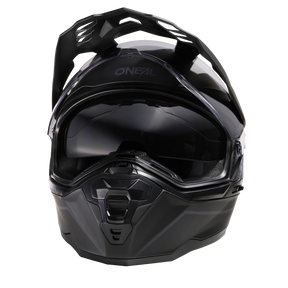 Il casco O'NEAL D-SRS Solid, di colore nero, è caratterizzato da una visiera e da un design angolare, che viene visualizzato frontalmente su uno sfondo monocolore.