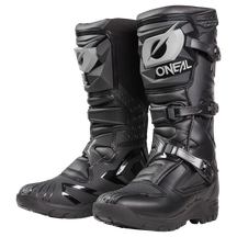 Der O'NEAL RSX Adventure Boot ist ein schwarzer Off-Road-Motorradstiefel mit grauen Akzenten, Schutzschnallen, strukturierten Sohlen und einem robusten Design für Abenteuerfahrten.
