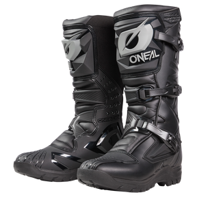 Der O'NEAL RSX Adventure Boot ist ein schwarzer Off-Road-Motorradstiefel mit grauen Akzenten, Schutzschnallen, strukturierten Sohlen und einem robusten Design für Abenteuerfahrten.