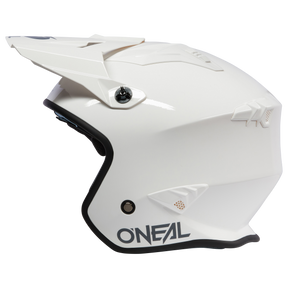 A white O'NEAL VOLT helmet SOLID motocross helmet with a visor, seen from the side. It has black inner padding and the O'NEAL logo in black on the lower edge.