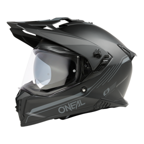 Un casque O'NEAL A-SRS SOLID noir mat avec une visière claire, un design anguleux et aérodynamique, vue de côté sur fond noir. Bluetooth-ready pour une connectivité facile.