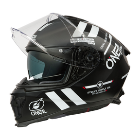 El casco O'NEAL Challenger WARHAWK es un casco integral negro con visera transparente, gráficos blancos, logotipos, diseño aerodinámico y mecanismo de visera lateral, ideal para los aficionados a las motos. Se muestra sobre un fondo blanco liso.