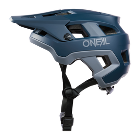 El casco O'NEAL Defender Solid en azul y gris tiene visera, aberturas laterales de ventilación y mentonera ajustable, mostrado aquí en vista lateral.