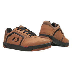 A pair of O'NEAL PINNED FLAT pedal shoe low-top brown sports shoes with black soles and laces, with excellent flat pedal grip. One shoe stands upright while the other turns slightly to show the sole. Brand: O'NEAL.