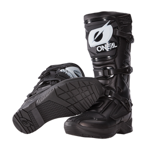 Un par de botas negras O'NEAL RSX: una de pie y otra de lado para mostrar la suela y la banda de rodadura. Estas botas MX de O'NEAL cuentan con robustas hebillas y duraderas placas protectoras para una seguridad óptima en la conducción.
