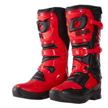 Un robusto par de botas O'NEAL RSX rojas y negras con hebillas, suela texturizada y llamativo logotipo, diseñadas para la conducción en moto todoterreno.