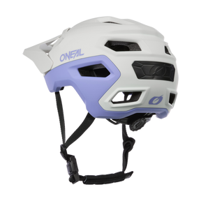 El casco O'NEAL TRAILFINDER EVO Solid en blanco y lavanda se muestra de lado sobre un fondo blanco y tiene aberturas de ventilación, una correa ajustable en la barbilla y una rueda de ajuste trasera.