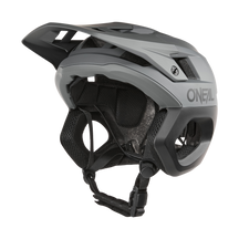 The O'NEAL TRAPPER Helmet SOLID is a gray and black bike helmet with visor, ventilation and adjustable chin strap for safety and comfort. Ideal as an enduro helmet from O'NEAL for versatile cycling adventures.