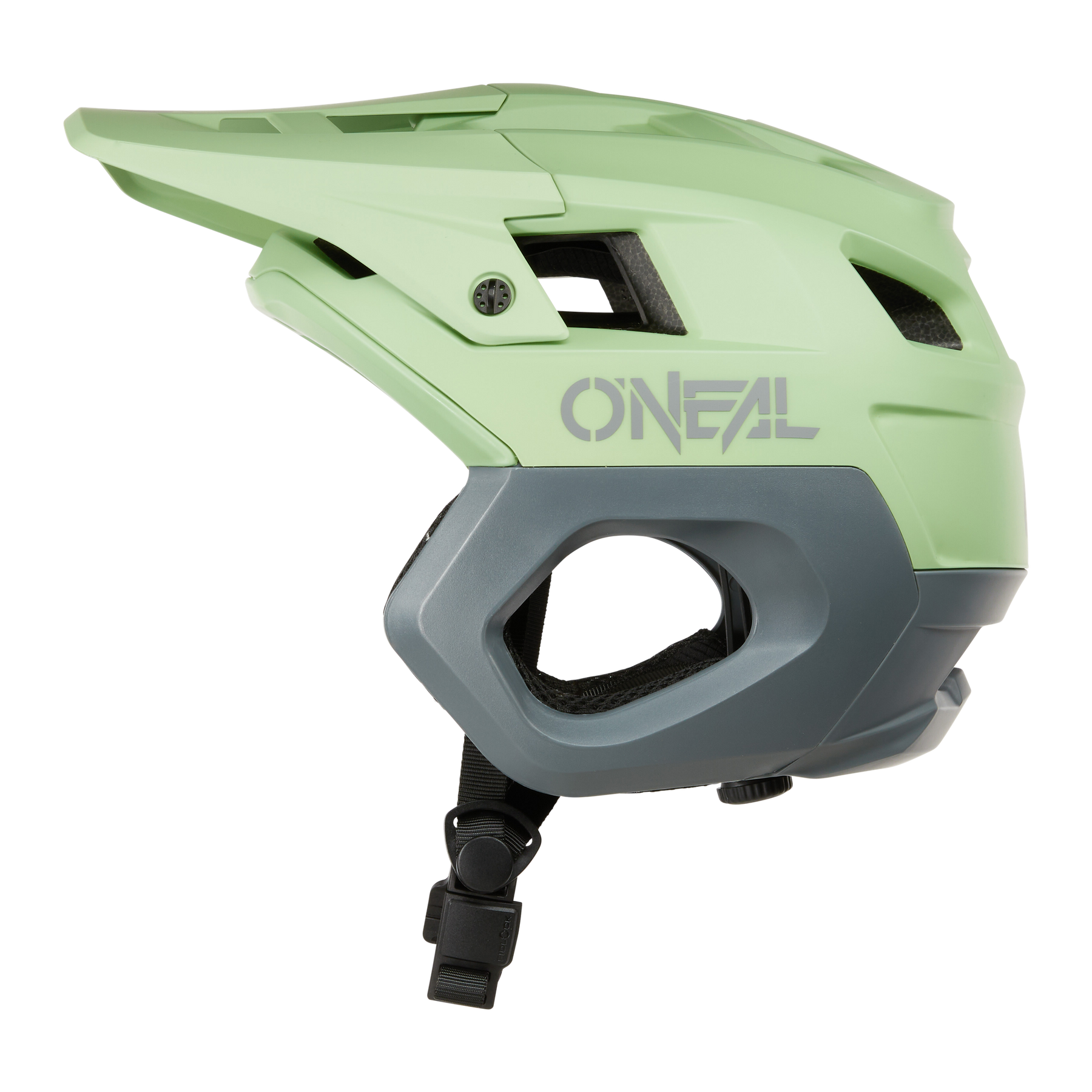Le casque O'NEAL TRAPPER SOLID en vert clair et gris dispose d'une visière, d'une mentonnière réglable et d'ouvertures de ventilation. Il est représenté de côté sur un fond blanc et est parfait pour les courses polyvalentes d'enduro et de VTT tout-terrain.