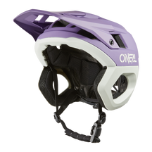 A purple and white O'NEAL TRAPPER helmet SOLID with extended visor, ventilation slits, black inner padding and adjustable chin strap.