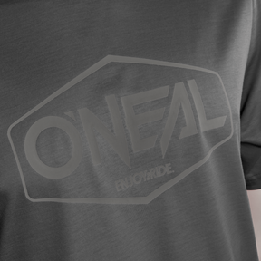 Nahaufnahme des grauen Mountainbike-Trikots O'NEAL VAULT Jersey mit dem O'NEAL-Logo und dem darunter in einem helleren Farbton aufgedruckten "ENJOY RIDE.". Dieses atmungsaktive, antibakterielle Trikot bietet Komfort auf jeder Fahrt.