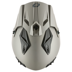 Die Draufsicht auf den grauen, kantigen O'NEAL VOLT Helm SOLID zeigt zwei schwarze Lüftungsschlitze und ein zentrales Emblem auf der Vorderseite, das für mehr Sicherheit sorgt.