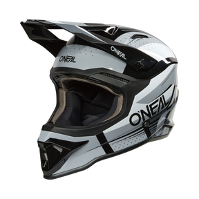 L'O'NEAL 1SRS Helmet RC è un casco da motocross nero/grigio con visiera e design aerodinamico, con il logo O'NEAL sul lato.