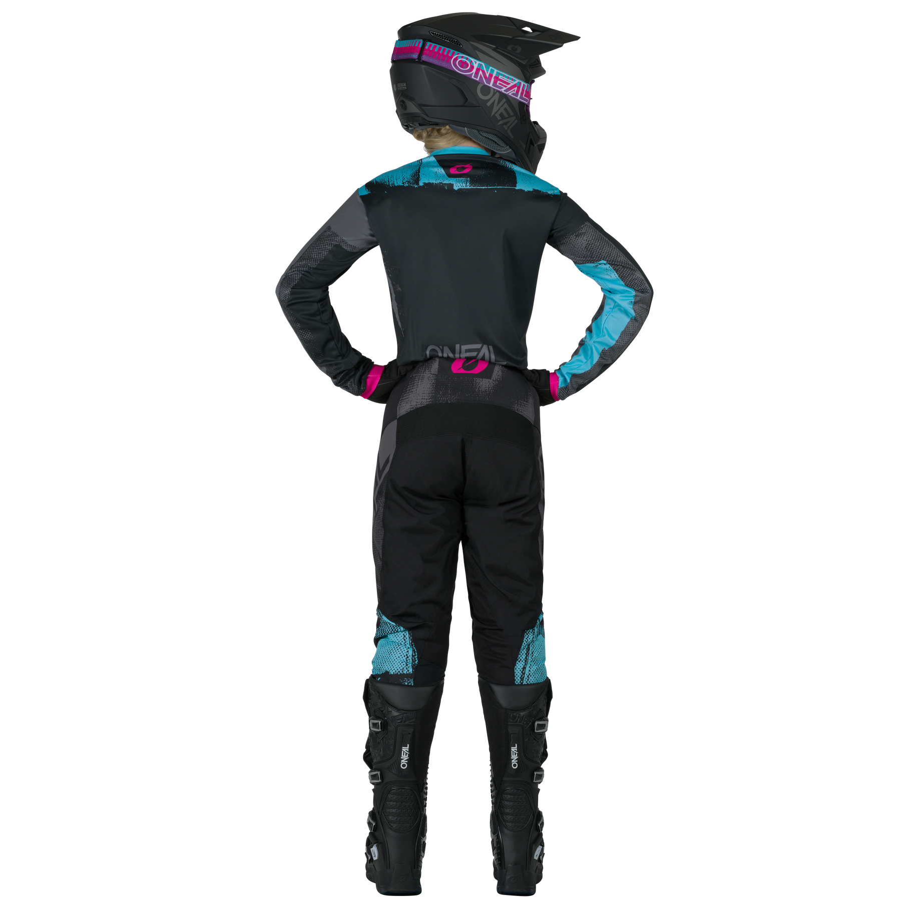 Eine Person steht mit den Händen in den Hüften und trägt die O'NEAL ELEMENT Women's Pants ROLLER von O'NEAL sowie einen schwarz-blau-pinken Motocross-Anzug, einen Helm und schwarze Motocross-Stiefel.